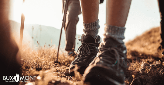 Close-up of hiking boots walking on trail