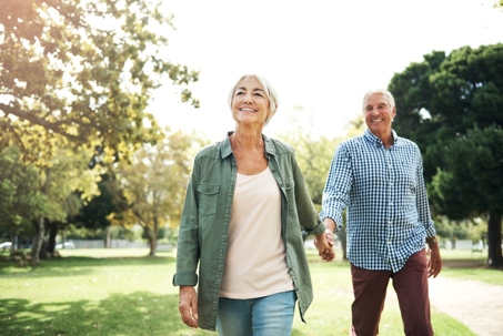 older-couple-holding-hands-walking-outside
